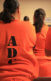 An image of a room of women in prison in orange prison uniforms.