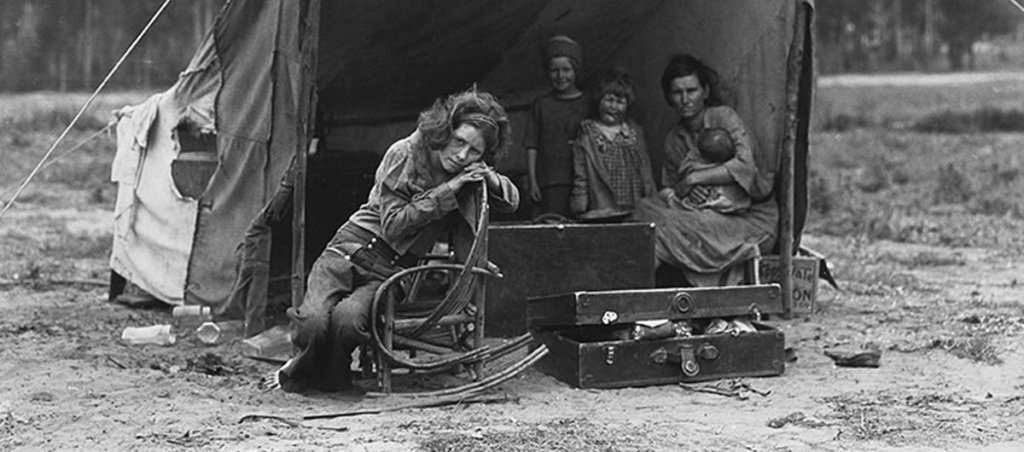 A photo of five people in a makeshift tent in the early 20th century.