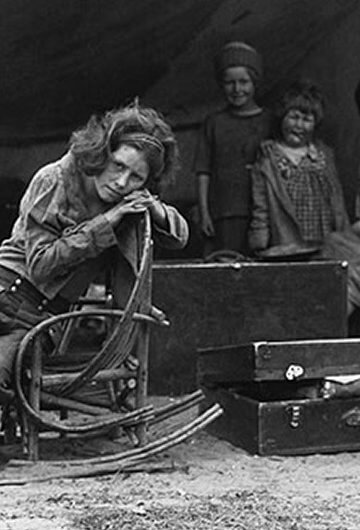 A photo of five people in a makeshift tent in the early 20th century.