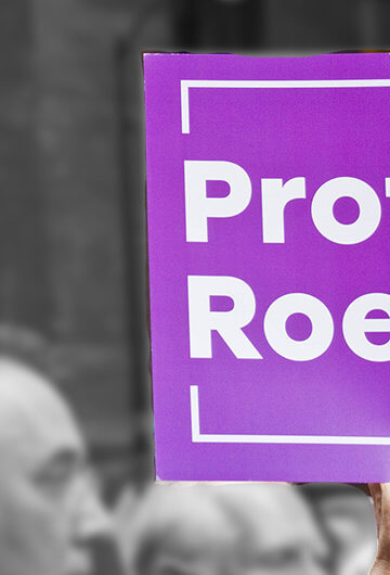 A photo from a protest with someone holding a sign that says "Protect Roe"