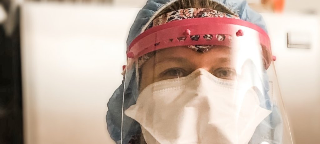 A photo's face of a nurse wearing PPE, including a mask and a visor.