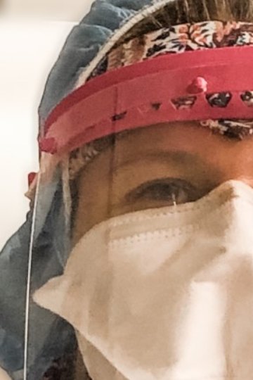 A photo's face of a nurse wearing PPE, including a mask and a visor.