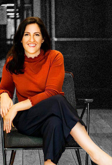 A photo of Stephanie Nadi Olson sitting in a chair.