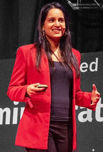 A photo of Nandini Jammi speaking onstage.