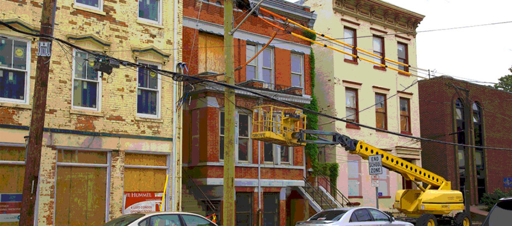 A photo of three houses with a construction in front of one of them.