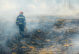 photo of firefighter walking in burned land