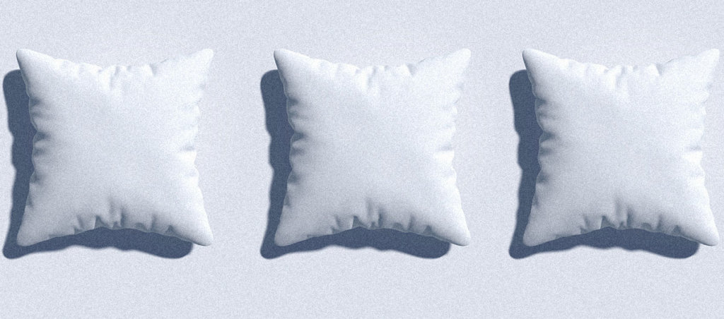 Three white pillows in a row on light blue background.
