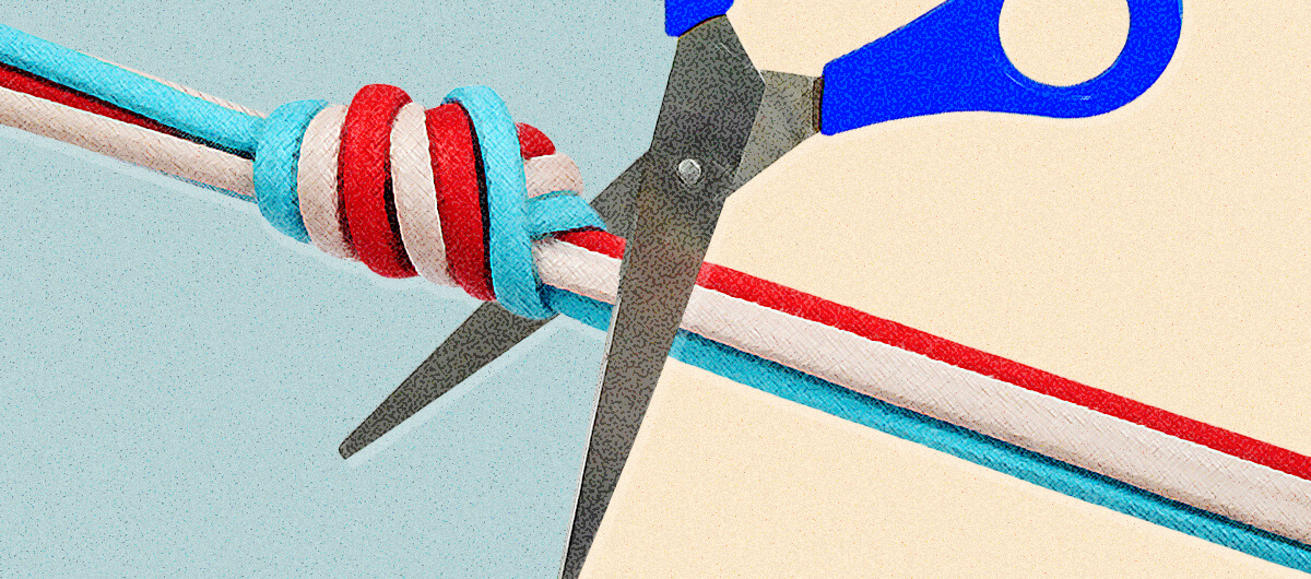 Someone cutting a rope of red, white and blue strings with scissors