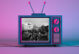 image of an older television, colored purple and pink with a photo of the insurrection on the capitol on the screen