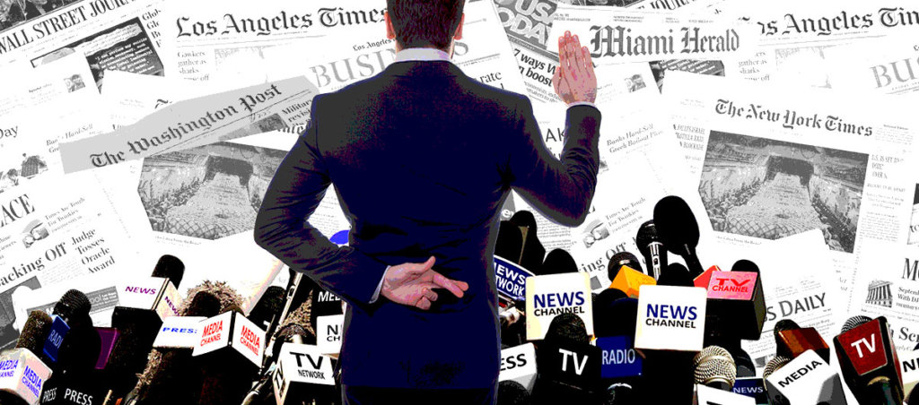 Man with hands behind back, crossing fingers in front of newspapers and microphones.