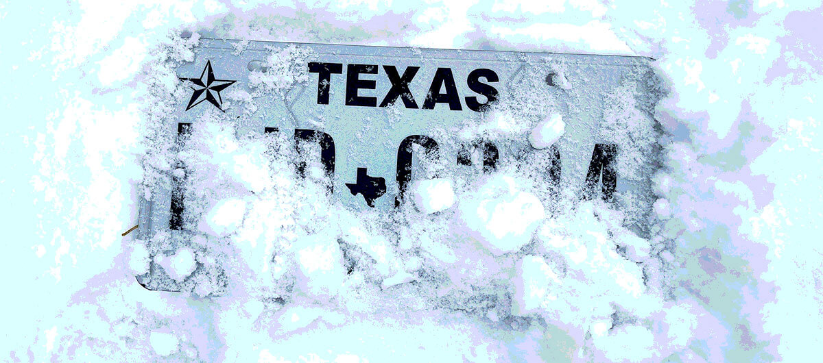 Image of a Texas license plate partially buried in snow