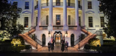 Image of White House rotunda with 500 candles representing 500,000 deaths. Vice President Kamala Harrs, Second Gentleman Doug Emhoff, President Joe Biden and First Lady Jill Biden stand solemnly in front of the display.