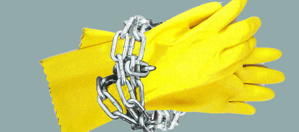 Yellow cleaning gloves with chains around wrist part to convey human trafficking