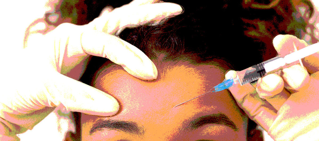 Black woman with a botox needle being injected into her forehead