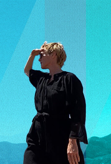 A woman looking into the distance with her hand blocking out the sun.