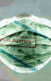 a surgical mask covered in dollar bills conveying medical debt