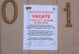 A sign on a door from NYC Buildings that says "Vacate: The Department of Buildings Has Determined that conditions within these premises are imminently perilous to life. This premises has been vacated and rrentry is prohibited until such conditions has been eliminated to the satisfaction of the department. Violators of the commissioner's vacate order are subject to arrest."