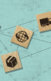 icons of a plane, truck, ship on wood tiles to convey supply chain. They are scattered on a bluish background with dots connecting throughout.