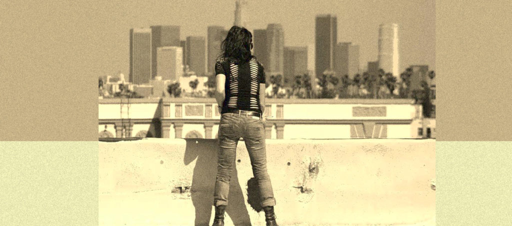 A photo of Diviana Ingravallo looking into a city from the rooftop from behind