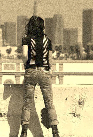 A photo of Diviana Ingravallo looking into a city from the rooftop from behind