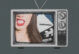 A tv with the lower half of woman's face sneering, and a script and clapboard behind her