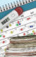 A collage with a thermometer on top of calendar. There is also a stack of files.