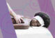 A Black woman, on a massage table, getting a massage. She has a blissful expression on her face.