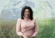 A photo of Dr. Beverly Wright, a Black woman, in front of a transparent image of the Earth globe, with two fields in the background.