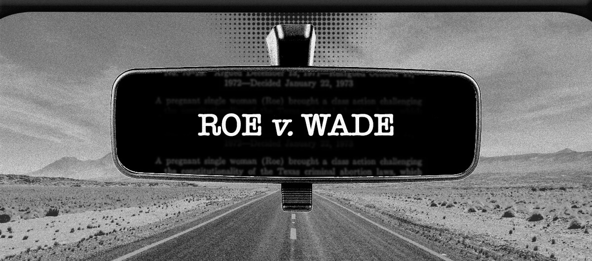 Roe v Wade on the car mirror with a desert road in the background