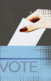 A hand of someone white white skin dropping a ballot into a blue box with the words "vote" on it.