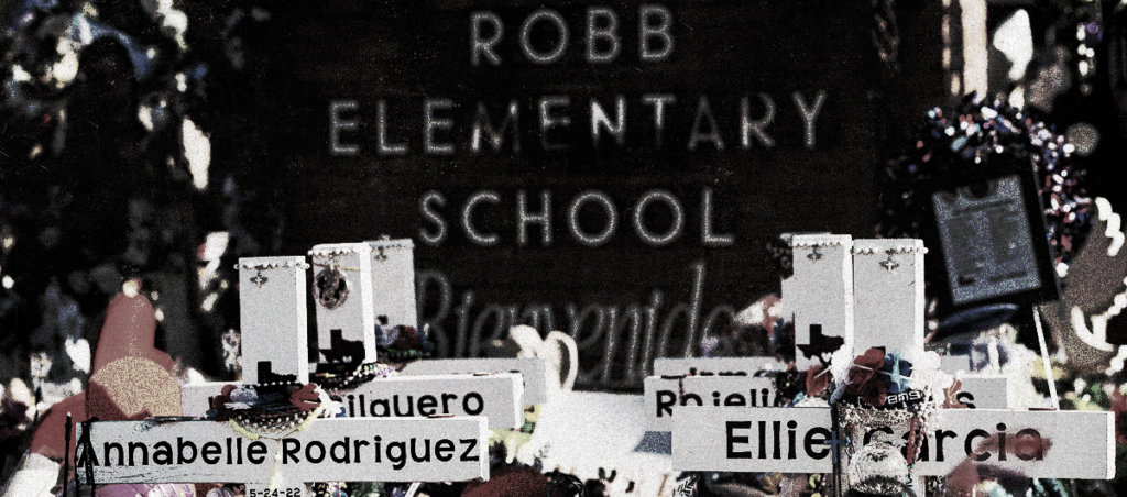 Crosses with names of deceased students with the words "Robb Elementary School" in the background.
