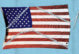 An illustration of the American flag having been sewn back together. The stitches are visible, and the needle still has thread in it.