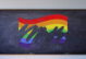 Image of a LGBTQ flag on a school blackboard. The flag is being erased as if it were drawn in chalk.