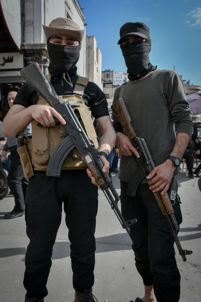 Two government soldiers on patrol in south Damascus. The men are looking at the camera and holding weapons