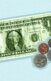 An image of a dollar bill with some coins next to it.
